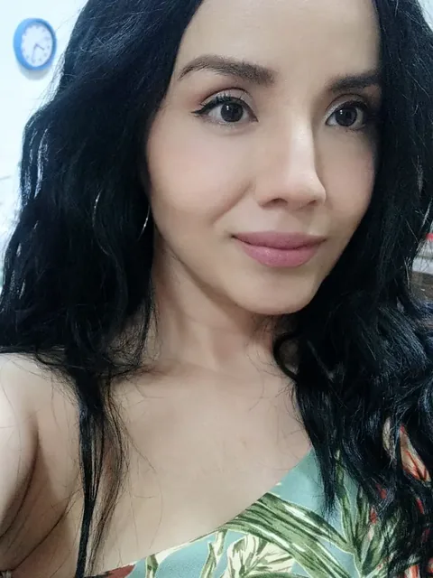 Woman with long black hair smiling softly