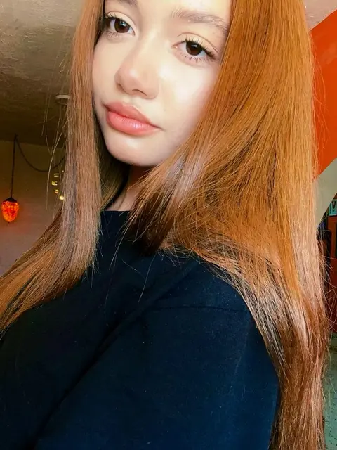 Woman with long copper hair looking at the camera
