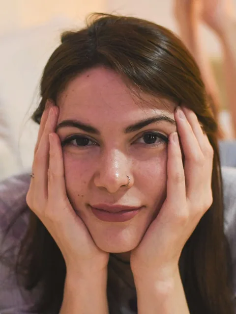 Woman resting her face in both hands and smiling