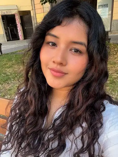 Woman with long curly hair smiling outdoors